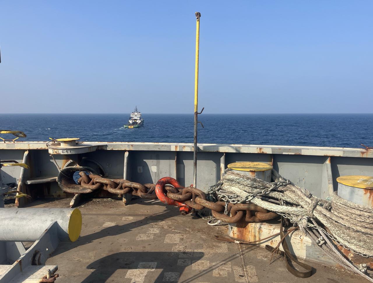 Towing chain rigged on deck with tug vessel ahead at sea