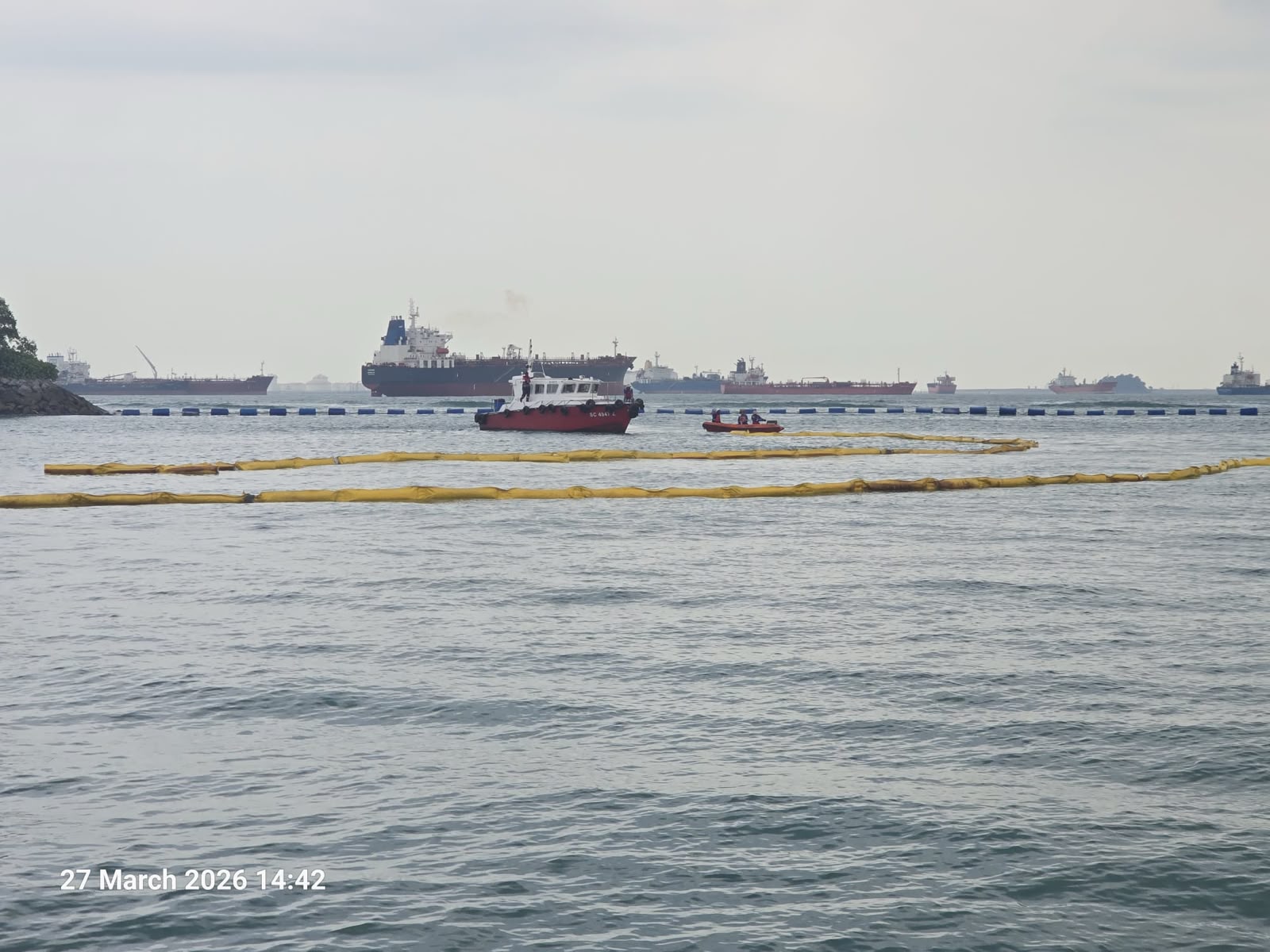 Containment booms deployed around response vessels at sea