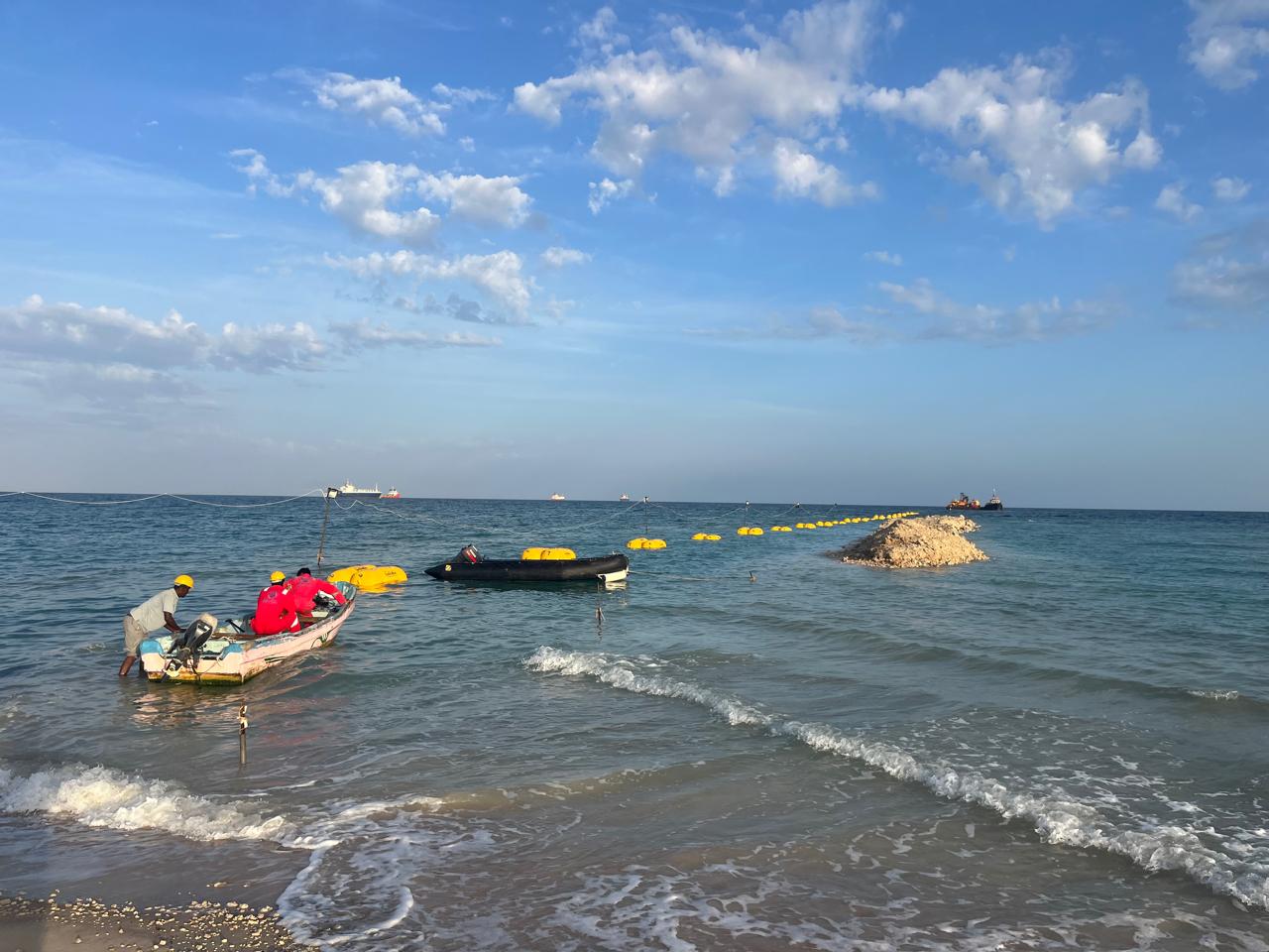 Shoreline protection booms and response boats near the beach