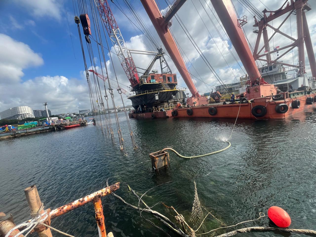Floating crane barge recovering a vessel casualty in harbor
